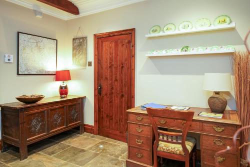 an office with a wooden desk and a table with a lamp at Cadshaw Country Views in Darwen