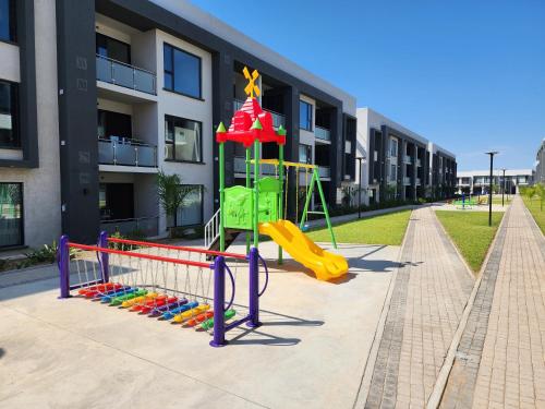 Un parque infantil frente a un edificio con un tobogán. en Starlight Haven, en Gaborone