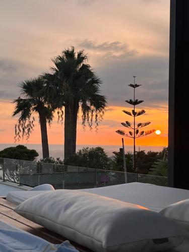 a view of a bed with a sunset in the background at Villa Essencia in Zahara de los Atunes