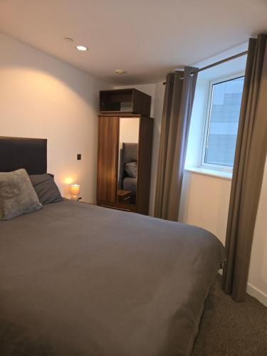 een slaapkamer met een groot bed en een raam bij Lovely one private bedroom in shared 2 bedroom apartment in Manchester