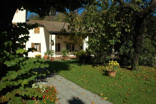 une maison blanche avec un jardin et une allée. dans l'établissement Albergo Volpara, à Mussolente 