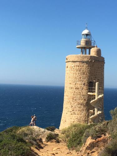a lighthouse on top of a cliff next to the ocean at Villa Essencia in Zahara de los Atunes