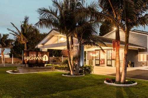 a hotel with palm trees in front of a building at Inn at Highway 1 in Lompoc