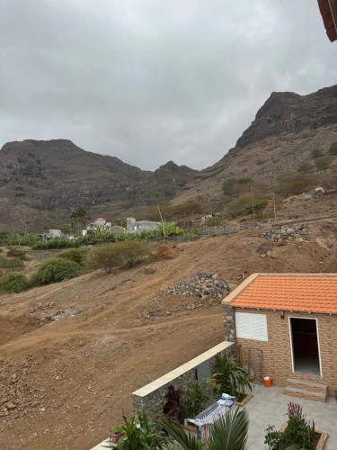 a house in a field with mountains in the background at Casa Carveiros Panoramic 360 in Tarrafal