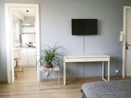 a bedroom with a table and a tv on a wall at Appartement Zen Strasbourg center avec parking in Strasbourg
