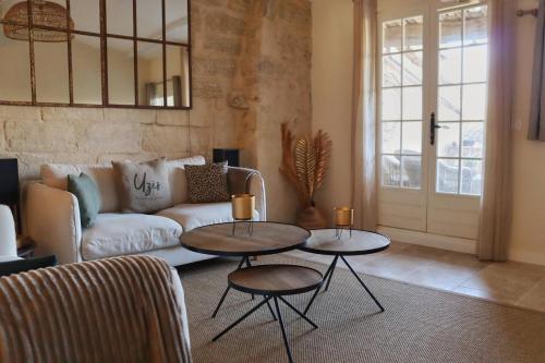 - un salon avec deux tables et un canapé dans l'établissement La Grande Bourgade-Authentique Maison en Pierre avec Terrasse Climatisation au Cœur d'Uzès, à Uzès