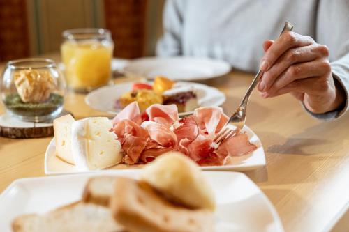 a person sitting at a table with a plate of food at Hotel Terme Antico Bagno in Pozza di Fassa