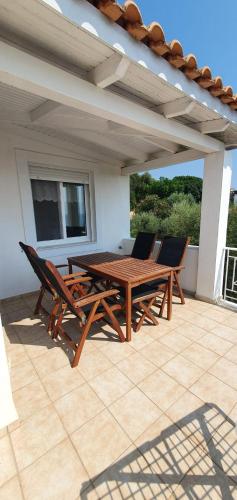 a wooden table and chairs on a patio at Methoni Vrisoules Poolvilla in Methoni