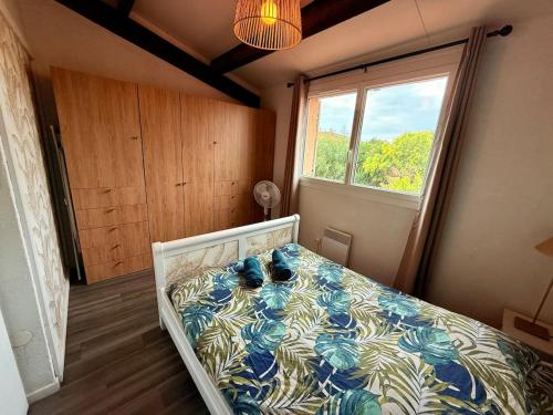 a bedroom with a bed in a room with a window at Maison du Cap Jacuzzi Wifi Clim Parking Court de tennis à 100m in Cap d'Agde