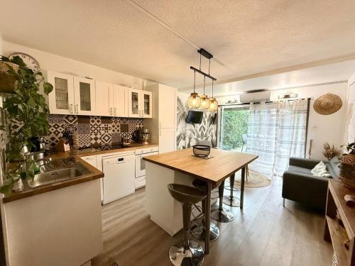 une cuisine avec une table et une salle à manger dans l'établissement Maison du Cap Jacuzzi Wifi Clim Parking Court de tennis à 100m, au Cap d'Agde