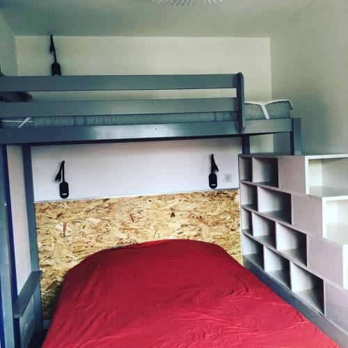 une chambre avec un lit superposé avec un couvre-lit rouge dans l'établissement La cabane de Biscarrosse, à Biscarrosse-Plage