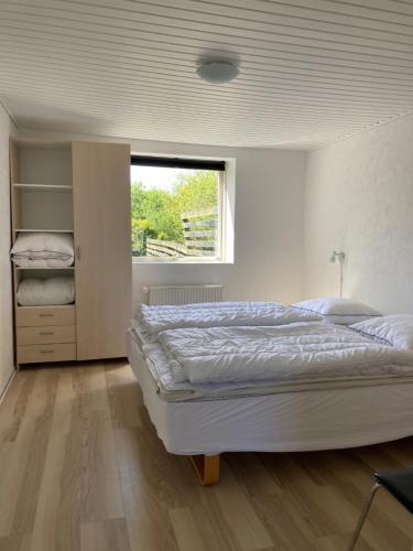 a bedroom with a large bed and a window at Nymindegab Ridecenter Ferienwohnung in Nørre Nebel