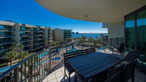 a balcony with a table and a swimming pool at Phoenix on the Bay 1411 condo in Orange Beach