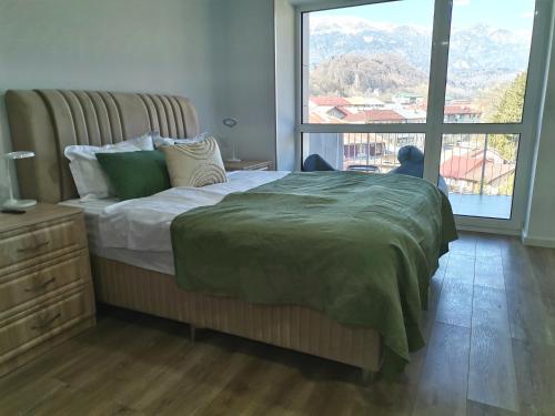 a bedroom with a bed and a large window at Tutu Studio Sinaia cu vedere panoramica Early Checkin in Sinaia