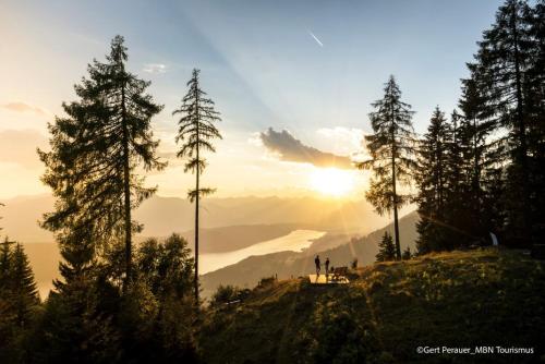 a group of people standing on top of a hill with the sunset at Pension Sedlak in Millstatt