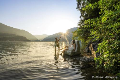 a woman and a child playing in the water at Pension Sedlak in Millstatt
