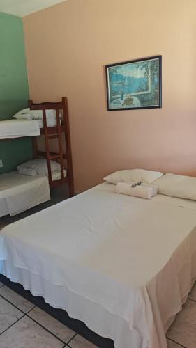 a bedroom with two beds and a picture on the wall at Pousada do Deck in Alcobaça