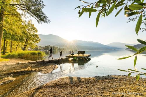 people walking on a dock on a lake at Pension Sedlak in Millstatt