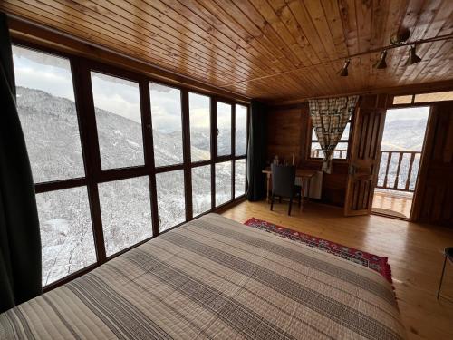 a bedroom with a large bed in a room with windows at Gentry House in Ambrolauri