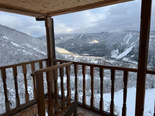 a view from a cabin balcony with snow covered mountains at Gentry House in Ambrolauri