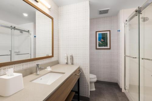 a bathroom with a sink and a toilet and a mirror at Hampton Inn & Suites Cottonwood, Az in Cottonwood
