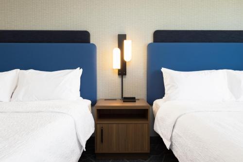 a hotel room with two beds and a table with two lamps at Hampton Inn & Suites Cottonwood, Az in Cottonwood