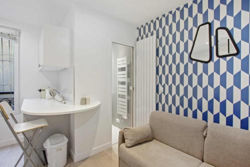 - un salon avec un canapé et un lavabo dans l'établissement Le Petit cosy de Montmartre, à Paris