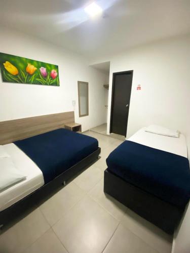 a bedroom with a bed and a painting on the wall at Hotel America 52 in Rionegro