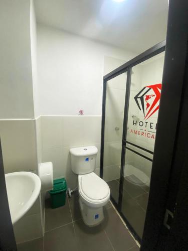 a bathroom with a toilet and a sink at Hotel America 52 in Rionegro