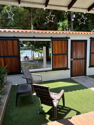 a patio with two chairs and a grass floor at Malibu beach in Punta de Piedra