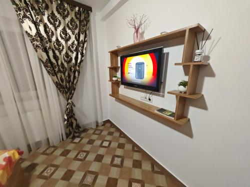 a tv sitting on a wall in a room at Apartament Luca in Călimăneşti