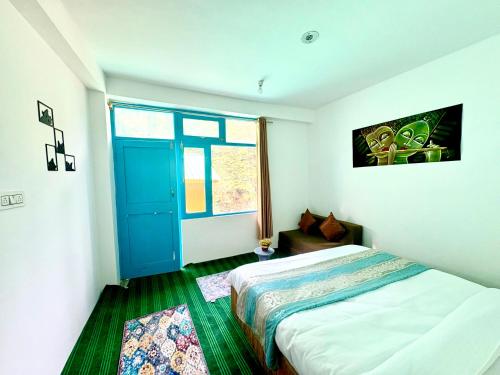 a bedroom with a bed and a blue door at Pine Nest Deluxe Rooms in Jibhi