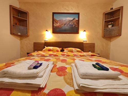 a bedroom with a large bed with towels on it at Apartament Luca in Călimăneşti