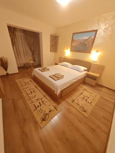 a bedroom with a bed and two rugs on the floor at Apartament Luca in Călimăneşti