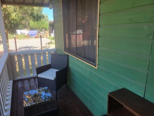 a porch with a chair and a window at Ananda Lodge A special haven in Punta Del Diablo