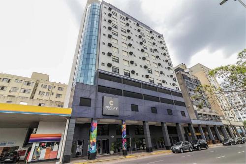 a tall building on a city street with cars parked in front at Century Park by My Way in Porto Alegre