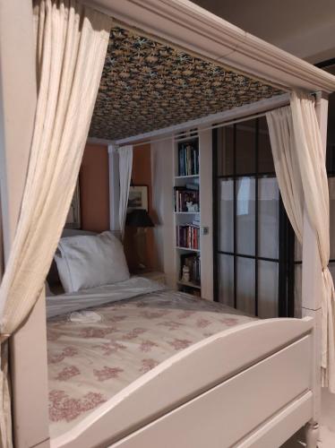 une chambre avec un lit à baldaquin avec rideaux dans l'établissement Studio en ville, à Bergerac