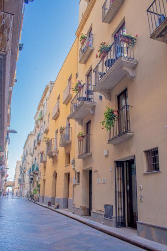 a yellow building with balconies on a street at Porta delle Botteghelle in Trapani
