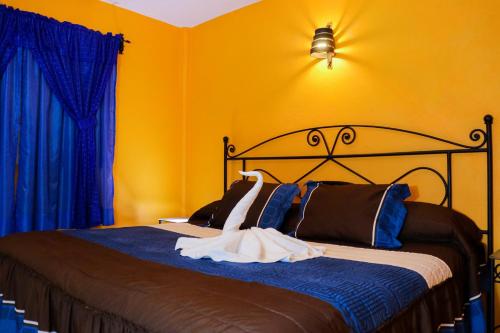 a bedroom with a bed with blue and yellow walls at Hotel Cristal Chignahuapan in Chignahuapan