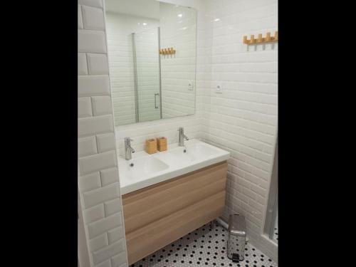 une salle de bain blanche avec un lavabo et un miroir dans l'établissement La Garenne Colombes centre, à La Garenne-Colombes