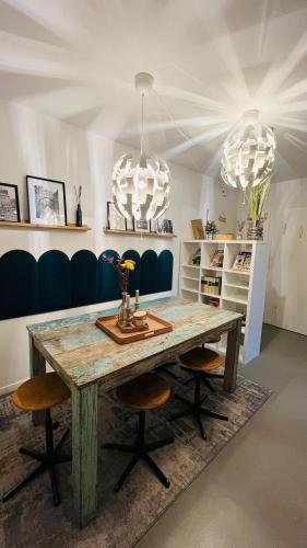 a dining room with a wooden table and two chandeliers at Daheim in Essen in Essen