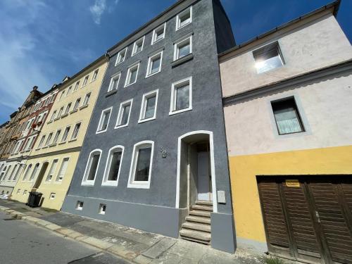 a gray building with a door on a street at Wunderschönes Meissen - Apartment in der Innenstadt No6 in Meißen