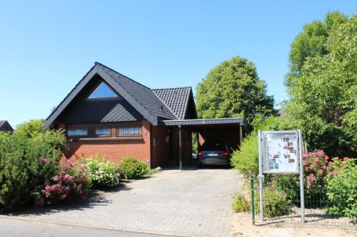 a house with a car parked in the driveway at Ferienhaus Sandfoort In Friedrichskoog Spitze in Friedrichskoog