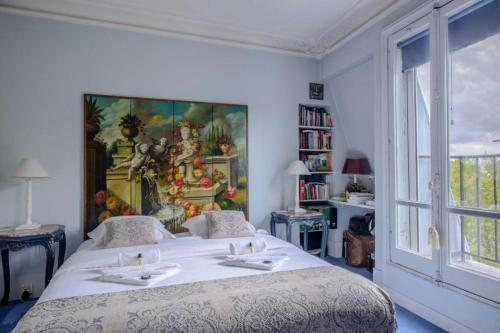une chambre avec un lit avec un tableau sur le mur dans l'établissement GuestReady - Luxury Apartment on the Ile de la Cit, à Paris