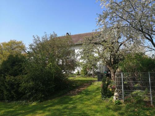 a white house with a fence in the yard at Große Ferienwohnung In Sinbronn Mit Garten in Dinkelsbühl