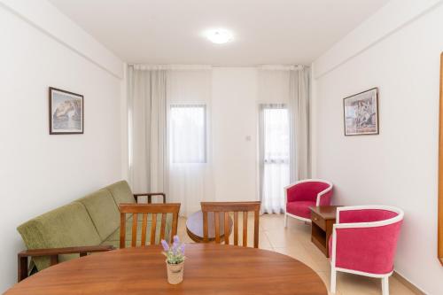 a living room with a table and chairs at Flora Hotel Apartments in Protaras