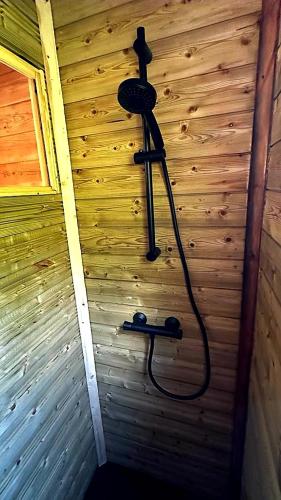 une douche dans l'angle d'un mur en bois dans l'établissement Cabanes du Puy Mary, à Cheylade