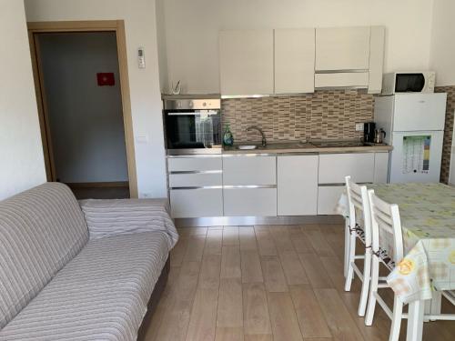 a living room with a couch and a table and a kitchen at CAV Mameli in Dorgali
