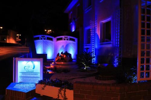 a house with blue and purple lights in a yard at Ferienwohnung Vulkaneifel in Daun