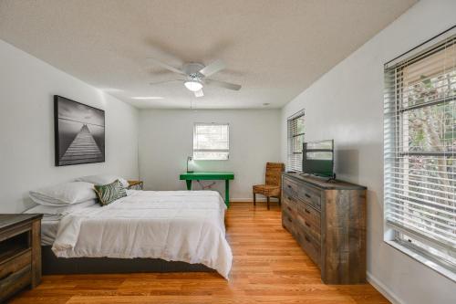 Un dormitorio con una cama, un televisor y una mesa. en 3 Mi to Naples Botanical Garden Home with Hot Tub!, en Naples